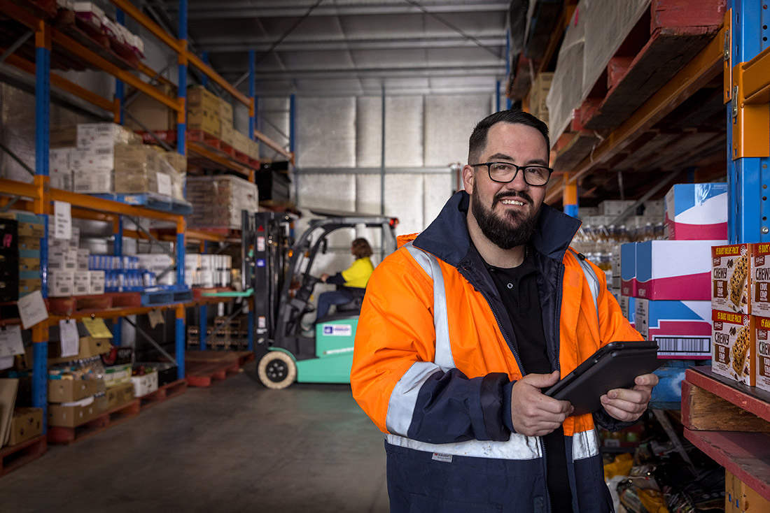 Mature-aged male educator in a warehousing setting.